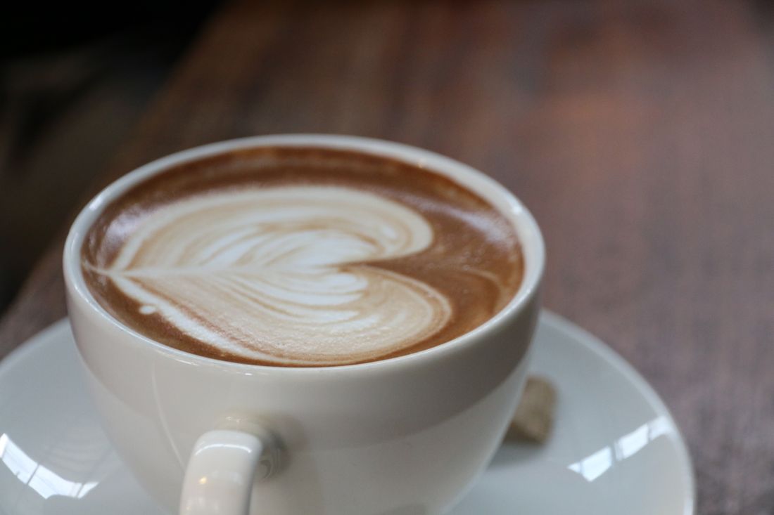 Cappuccino mit Latte-Art auf dem Cafétisch